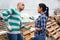 Latino man and woman talking near greenhouse