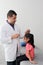 Latino pediatrician specialist doctor measures the head of his patient, a small 4-year-old brunette girl checks her measurements d