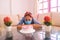 Latino woman in medical mask celebrating her birthday alone near birthday cake