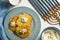 Latkes and curd cheese on a plate and on a blue napkin, chanukia