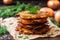 latkes stacked on parchment paper with a sprig of parsley on top