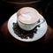 Latte art, coffee in coffee beans and Asian pottery background