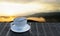 Latte art coffee, milk foam topped with chocolate sauce In a white mug On the slat table The background is a blurry mountain image