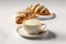 Latte art with two delicious croissants over white background.