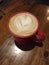 Latte with a Heart, Coffee in a Red Mug on a Wooden Cafe Table