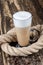 Latte macchiato in beautiful cup on wooden background with natural shadow. Cappuccino frothy coffee and milk drink in clear glass