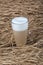 Latte macchiato in beautiful cup on wooden background with natural shadow. Cappuccino frothy coffee and milk drink in clear glass