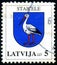 LATVIA - CIRCA 2007: stamp 5 Latvian santim printed by Republic of Latvia, shows stylized Stork / Crane, Coat of Arms of Staicele