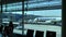 Latvia, Riga, 23 April 2019: Passengers sit on benches waiting for boarding to plane, windows overlooking a airport