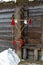 Latvian Puzurs with red ribbons hanging at log hut. Puzurs is traditional Latvian room decoration made of straws