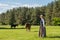 Latvian woman in traditional clothing posing on nature with horse in village.