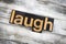 Laugh Letterpress Word on Wooden Background