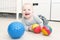 Laughing 6 month cute baby girl plays balls