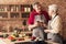 Laughing affectionate retired couple drinking wine together in kitchen