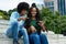 Laughing african american male and female influencer posting message with mobile phone