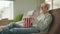 Laughing albino man watching comedy, sitting on sofa in house, eating popcorn