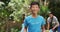 Laughing asian boy wearing volunteer t shirt holding refuse sack for collecting plastic waste