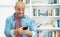 Laughing bald man sending message at mobile phone