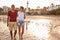 Laughing barefoot couple on the beach