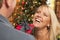 Laughing Blonde Girl Exchanging Gifts in front of Christmas Tree