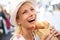 Laughing blonde woman savouring Focaccia sandwich