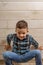 Laughing boy of 4 years old in a blue tart shirt on a light wooden background