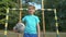 Laughing boy goalkeeper looking into camera, standing with ball at pitch, hobby