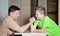 Laughing boy and his dad competing in physical strength. Father arm wrestling with his son - happy family time together.