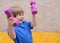 Laughing boy. Positive kid, 3 years old plays with dumbbells.