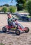 Laughing boy on a red pedal car