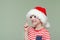 Laughing boy in a santa hat and glasses threatens finger