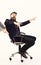 Laughing businessman sitting on the office chair and rolling