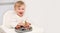 Laughing caucasian blonde toddler about 1-2 year old,eating from silicone plate fresh fruits, berries.Kids self-feeding