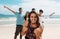 Laughing caucasian man with cheering young adults at beach