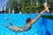 Laughing child with joyful mother swimming in the pool