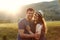 Laughing couple in love at sunset in nature, honeymoon, mountains, back light, soft light, emotions, laughing