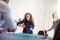 Laughing coworkers playing table tennis on an office table