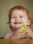 Laughing cute child eating apple fruit, portrait on blurred background. Enjoy eating moment. Healthy food and kid