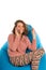 Laughing cute woman sitting on blue beanbag chair and talking on