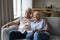 Laughing elderly spouses cuddle on couch watch tv movie comedy