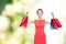 Laughing elegant woman in dress with shopping bags