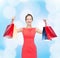 Laughing elegant woman in dress with shopping bags