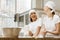 laughing female bakers kneading dough together