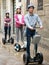 Laughing friends posing on segways on city street