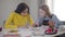 Laughing friends sitting at the table and doing homework. Caucasian and African American students having fun, teen