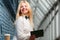 Laughing ginger woman holding note-book in long corridor