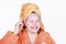 Laughing girl cleaning ears with cotton swab. Portrait teenage in towel on head