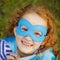 Laughing girl with superhero mask