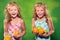 Laughing girls holding some fruit