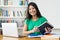 Laughing hispanic female student preparing for exam at desk